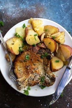 a white plate topped with meat and potatoes