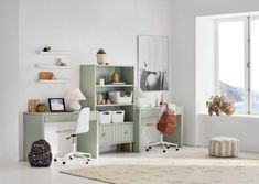 a room with a desk, chair and bookcase in it next to a window