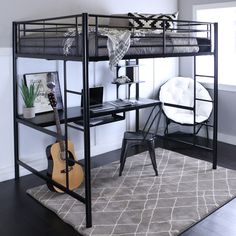 a bunk bed with a desk and guitar on it in a room next to a window