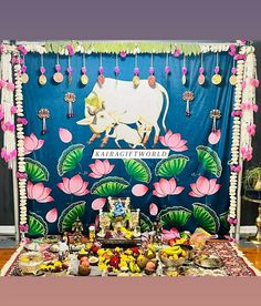 a table with food and decorations on it in front of a blue backdrop that says,