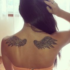 the back of a woman's body with wings on her upper and lower back