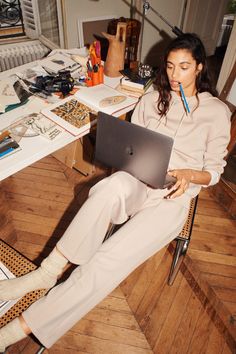 a woman sitting in a chair with a laptop on her lap