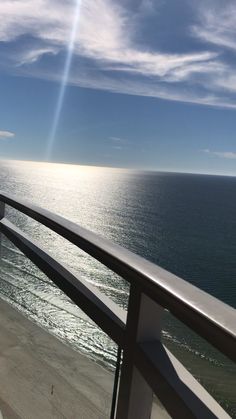 the sun shines brightly over the ocean as seen from a balcony