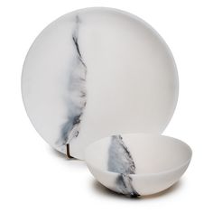 two white plates and one bowl with black marble on the top, both in different shapes