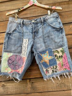 a pair of jean shorts with patches and flowers on them