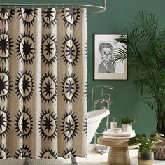 a bathroom with green walls and a shower curtain in the center is decorated with black and white sunbursts