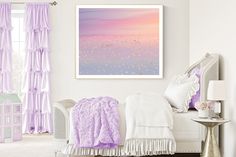 a bedroom with white walls and purple curtains on the window sill is decorated in pastel tones