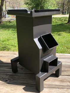 a metal trash can sitting on top of a wooden deck