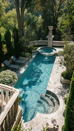 an outdoor swimming pool surrounded by greenery and stone steps with seating area on either side