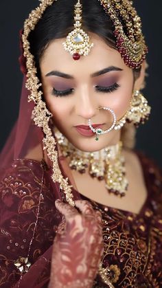 a woman wearing a bridal outfit and jewelry