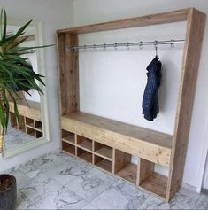 a wooden bench sitting next to a potted plant on top of a tiled floor