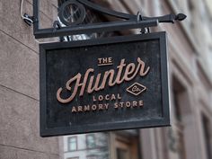 the sign for the hunter local armory store is hanging from the side of a building