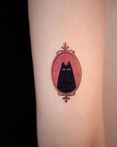 a black cat in a frame tattoo on the arm