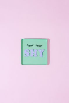 a square sticker with eyelashes and the word sul on it's side against a pink background