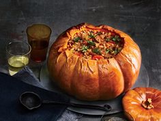 two pumpkins sitting next to each other on top of a table with utensils