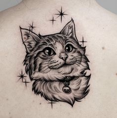 a cat tattoo on the back of a woman's upper arm and chest, with stars in the background