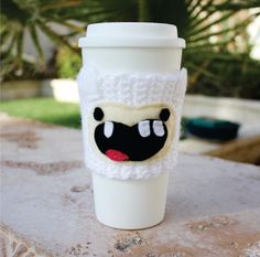 a coffee cup with a knitted face on it