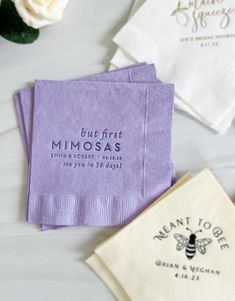 three napkins with the words blue first mimosas printed on them, one in purple and one in white