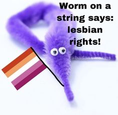 a purple worm with eyes and tongue sticking out of it's back, next to a rainbow flag