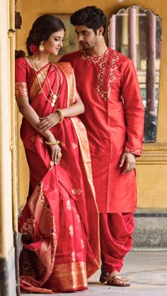 a man and woman dressed in red standing next to each other