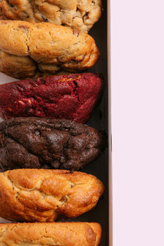 a box filled with assorted baked goods like cookies and chocolate chip muffins
