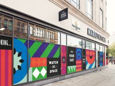 a store front with colorful posters on the windows