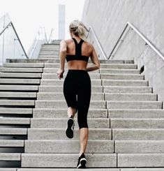 a woman is running down some stairs in black sports bra top and leggings