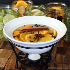 a white bowl filled with soup on top of a wooden table next to mason jars