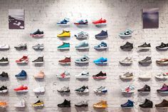 there are many pairs of shoes hanging on the wall in front of eachother