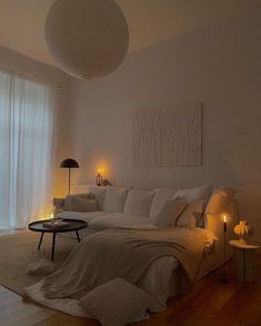 a bedroom with white walls and wooden floors