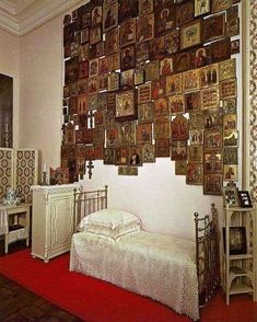 a bed sitting in a bedroom next to a wall with pictures on it's walls