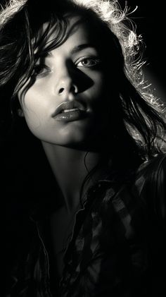 a black and white photo of a woman's face with her hair blowing in the wind