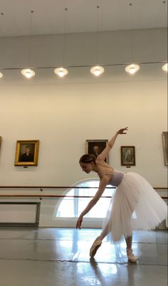 a ballerina in a white tutu is posing for the camera