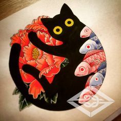 a black cat sitting on top of a table next to red flowers and orange fish