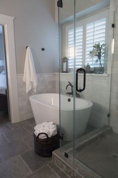 a white bath tub sitting inside of a bathroom next to a walk - in shower