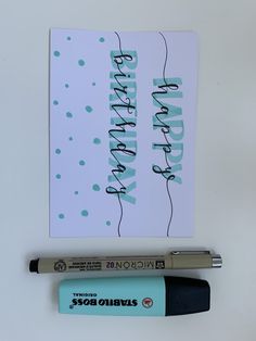 a birthday card next to a marker and pen on a white surface with polka dots