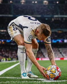 a man kneeling down next to a soccer ball