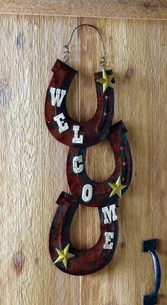 a wooden sign that says welcome hanging on a wall