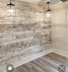 an empty room with wood paneling on the wall and ceiling fans hanging from the ceiling