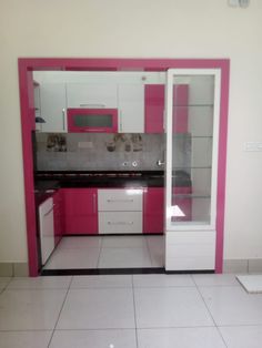 a kitchen with pink and white cabinetry in it's center area, on the floor is a tile floor