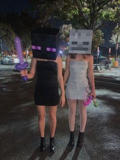 two women dressed up as minecraft characters walking down the street at night with purple balloons