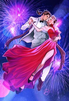 a man and woman dancing with fireworks in the background