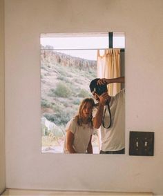 a man and woman taking a selfie in the mirror