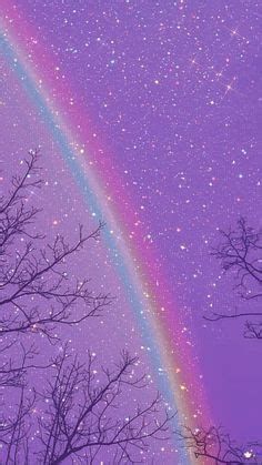 a rainbow shines brightly in the sky above trees