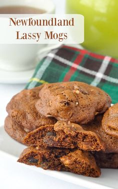 chocolate chip cookies stacked on top of each other next to a cup of coffee and a plaid napkin