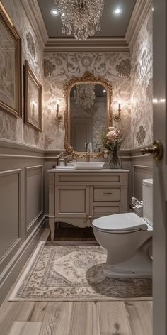 a bathroom with a toilet, mirror and chandelier