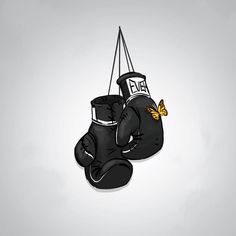 a pair of black boxing gloves hanging from a string with a butterfly on it's back