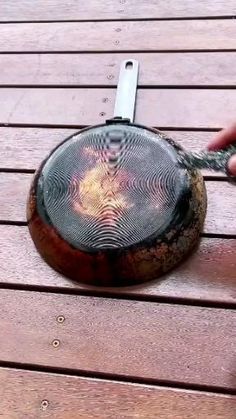 a person holding onto a piece of wood on top of a wooden table