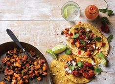 three tortillas on a table with salsa and limes