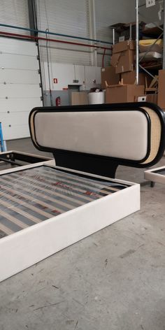 a bed frame sitting on top of a floor in a room filled with boxes and other items